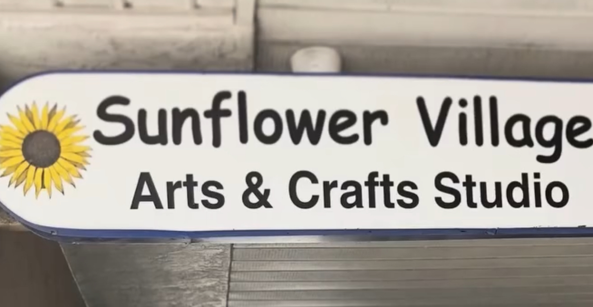 The full Sunflower Village Arts and Crafts Studio sign